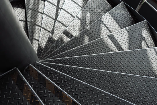 Int&eacute;rieur moderne avec escalier suspendu &agrave; structure m&eacute;tallique noire et marches en bois massif