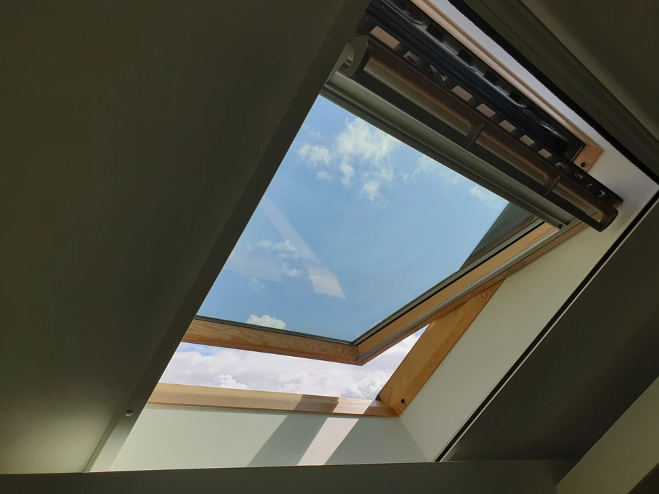 Artisan menuisier en équipement de sécurité professionnelle posant une fenêtre sur façade résidentielle. L'image montre un chantier impeccablement organisé avec le professionnel concentré sur son installation de qualité, démontrant rigueur et professionnalisme. Le chantier en arrière-plan est propre et rangé, équipements bien disposés. La scène capture le sérieux du travail et l'attention aux détails, reflétant transparence et excellence.