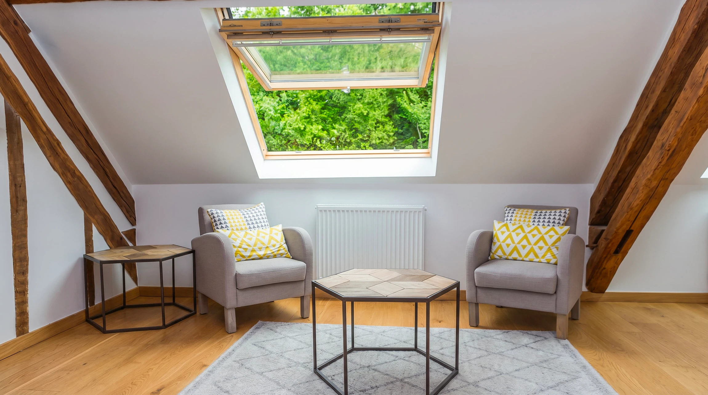 Fenêtre ouverte sur le toit de la lucarne sur plafond incliné dans la chambre mansardée, vue en basse angle