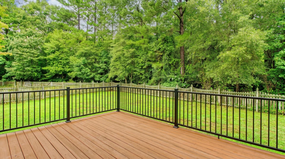 Une terrasse ou balcon extérieur moderne avec un garde-corps en aluminium ou acier inoxydable de couleur anthracite ou gris, présentant des barreaux horizontaux, installé sur une structure en bois ou béton. La scène montre une installation professionnelle, bien définie, photographiée en plein jour avec vue dégagée sur le paysage environnant ou un espace extérieur. L'image doit mettre en avant la qualité et la robustesse du garde-corps.