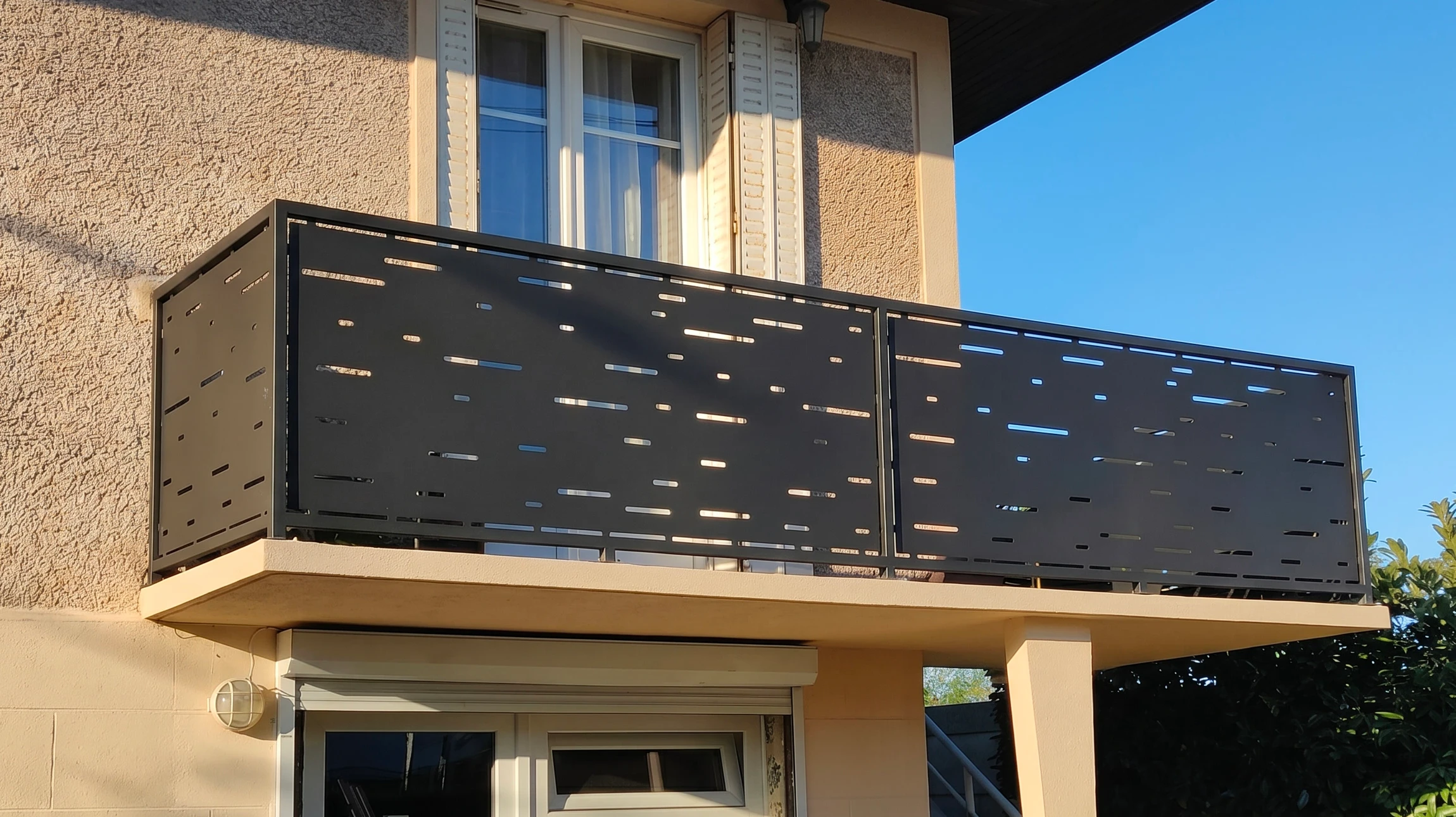 Scène extérieure montrant un système de garde-corps moderne avec câbles tendus horizontaux